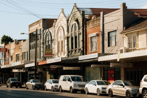 Willoughby shopfronts in Sydney with parked cars and warm morning light.
